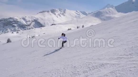 优雅的女滑雪者专业地在山上削坡视频的预览图