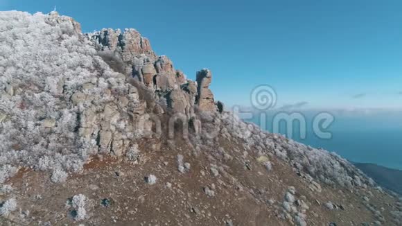 山顶上有巨大的巨石和雪白的针叶树蓝天映衬着美丽的景色射击山视频的预览图