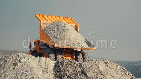 采矿装载机卸下石灰石矿石或岩石从后面看视频的预览图