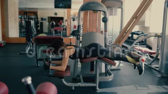 运动型美丽的黑发中年妇女在健身房锻炼腿部和臀部肌肉视频的预览图