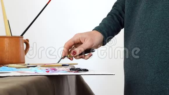 艺术家的女性手在黑板上混合颜色准备用丙烯酸颜料画一幅画视频的预览图