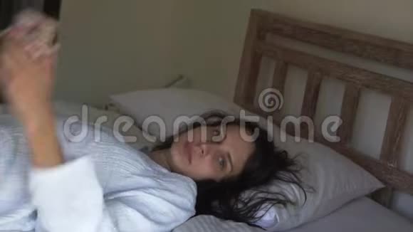 白人女性湿发躺在床上说话看镜头视频的预览图