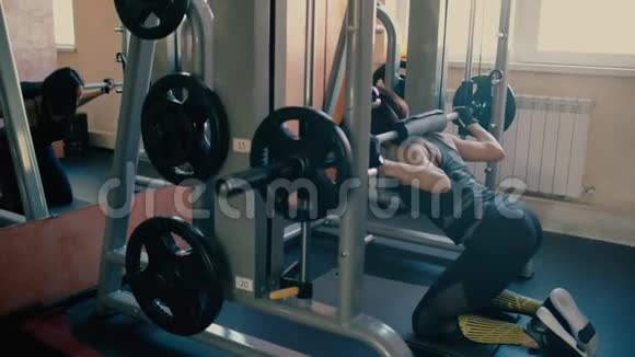 美丽的运动型黑发中年妇女在健身房做蹲式锻炼4千克视频的预览图