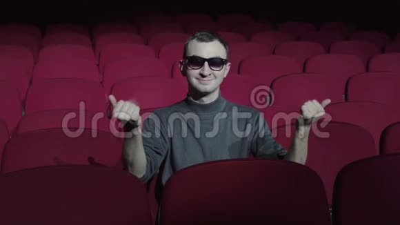 单身男子坐在黑色电影院舒适的红色椅子上并邀请加入视频的预览图