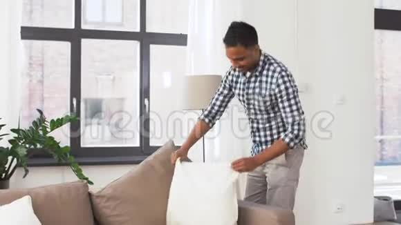 印度男人在家里布置沙发靠垫视频的预览图
