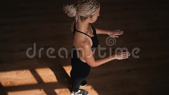 一位身材苗条的年轻金发女子在健身房从事健美操操她在健身场所跑步视频的预览图
