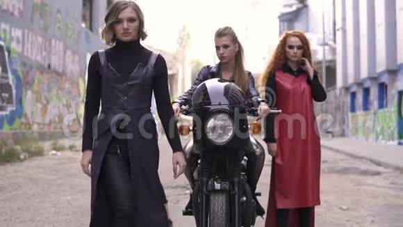四个古怪的时尚皮革女孩和黑色摩托车城市涂鸦现场的年轻朋克女人视频的预览图