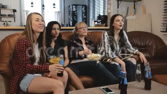 漂亮的欧洲女朋友在电视上看电影年轻迷人的女孩看情感电影4K慢动作视频的预览图
