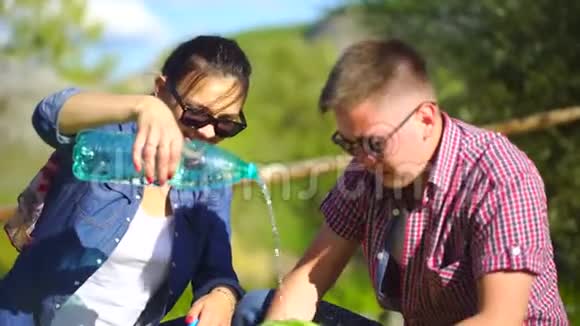 年轻人和女人在河边的森林里野餐吃西瓜合上洗西瓜4千克视频的预览图