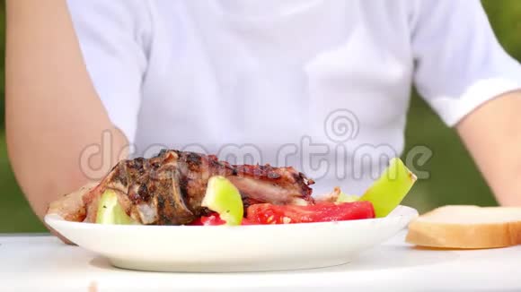 白色盘子的特写与什什烤肉串烧烤这孩子正在吃什什烤串在特写的自然视频的预览图