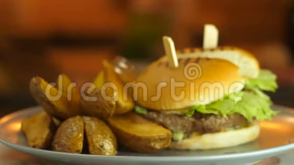 汉堡包是美味多汁的有切块奶酪咸黄瓜生菜和切碎的烤土豆视频的预览图