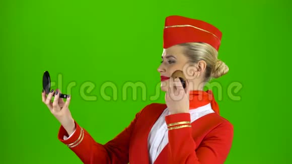 空姐看着镜子用流苏画着她的脸绿色屏幕视频的预览图