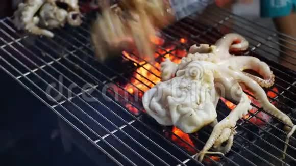 晚上在户外街头亚洲市场用烤章鱼做饭烧烤海鲜4k视频的预览图