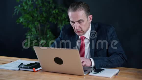 为笔记本电脑在办公室工作的商人或律师视频的预览图