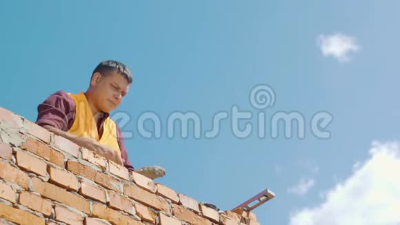 在蓝天背景下工作的砖匠视频的预览图