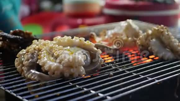 晚上在户外街头亚洲市场用烤章鱼做饭烧烤海鲜4k视频的预览图