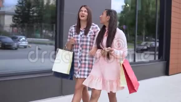 两个女孩买完东西后带着包裹去购物4K视频的预览图