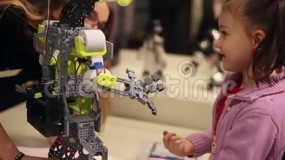 一个小女孩和一个女人在和一个机器人说话现代机器人技术人工智能控制论视频的预览图