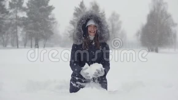 在冬天的公园里快乐地散步年轻女子在雪地里玩雪视频的预览图