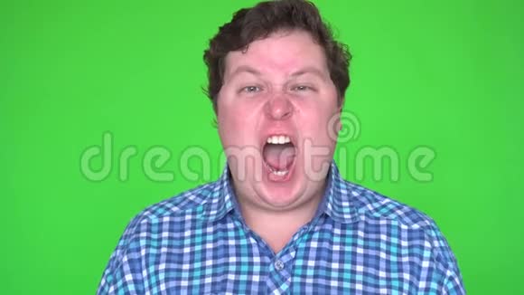 特写愤怒的胖子对着绿色背景尖叫视频的预览图