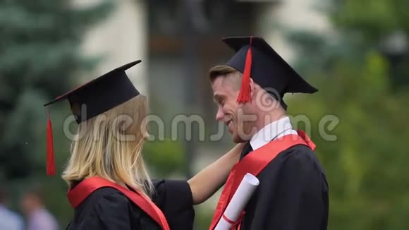 两个朋友在毕业典礼上拥抱年轻人庆祝自己的成就视频的预览图