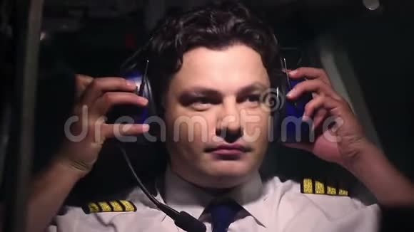 工作中的专业飞行员使用耳机与飞行控制器通信视频的预览图