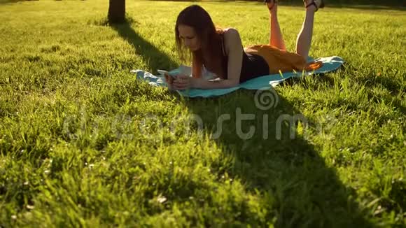 在打电话的时候躺在草地上的女人视频的预览图