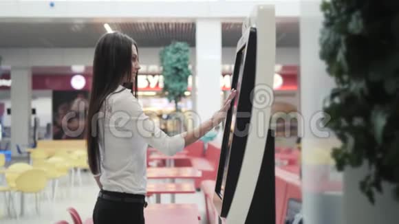 白人女性在购物中心站着时使用带有大数字屏幕的自动柜员机女性核实视频的预览图