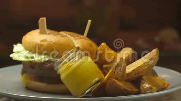 演示一个多汁的汉堡和一个大煎锅里面有薯条和蛋黄酱视频的预览图