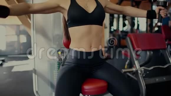 年轻漂亮的黑发女孩留着长发在健身中心做蝴蝶锻炼4千克视频的预览图