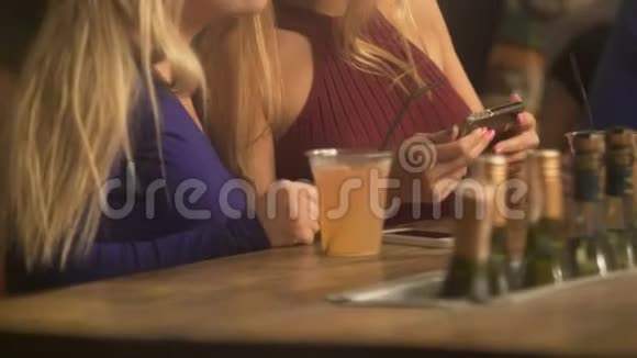 迷人的金发女郎在智能手机上看视频在酒吧里玩得开心视频的预览图