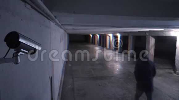 在监控摄像头的背景下晚上在地下通道上行走的危险人物视频的预览图