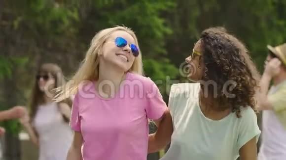 两位美丽的年轻女士在智能手机上跳舞笑着摆姿势自拍视频的预览图
