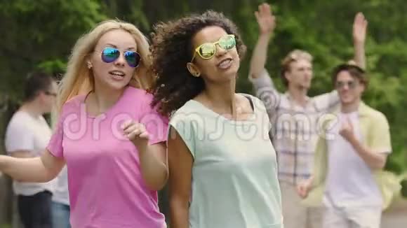两位快乐的女舞者在户外狂欢朋友们在公园里闲逛视频的预览图