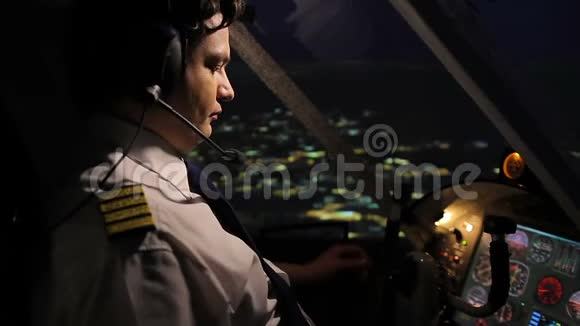 专业空勤人员指挥官夜间在城市上空驾驶飞机视频的预览图