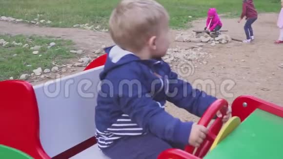 两岁开朗的男孩在玩具汽车秋千上玩波特瑞特视频的预览图