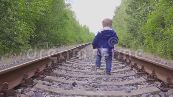 男孩在铁路上行走危险的游戏和娱乐活动夏日视频的预览图