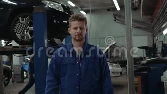 一位汽车修理工在修车厂工作时的画像一个微笑的人在工厂仓库里视频的预览图