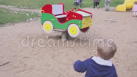 两岁开朗的男孩在玩具汽车秋千上玩波特瑞特视频的预览图