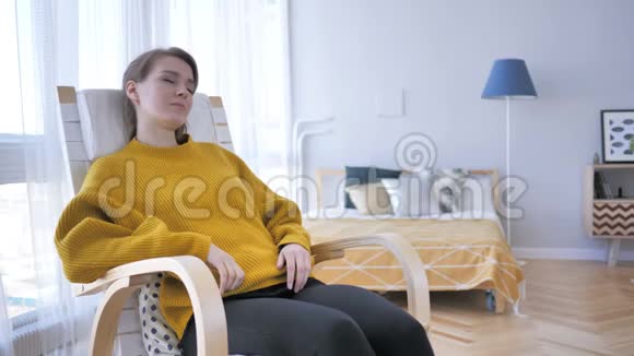 睡累的女人坐在休闲椅上视频的预览图