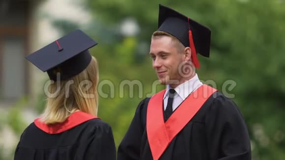 害羞的男人在毕业典礼上和女朋友交谈成就成功视频的预览图