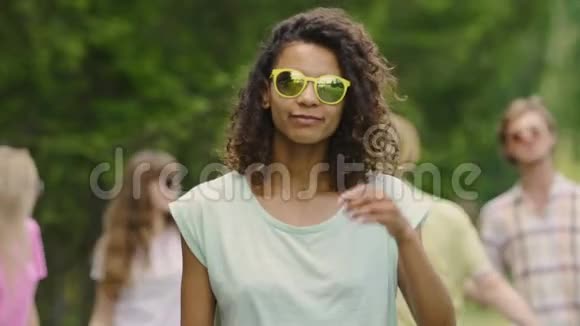 时尚的混血女孩在音乐节上跳舞朋友在公园里闲逛视频的预览图