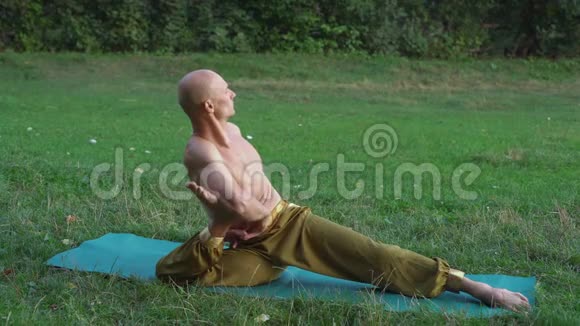 年轻的瑜伽修行者练习瑜伽体式早上在城市公园做运动视频的预览图