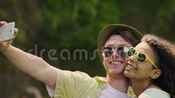 情侣爱在智能手机上自拍在公园享受美好的周末视频的预览图