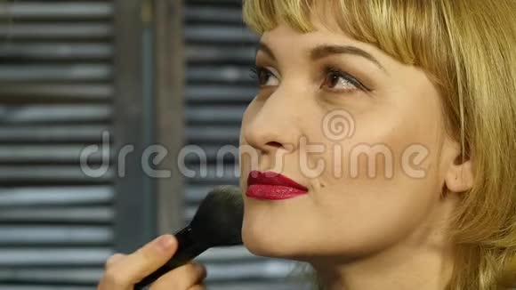 专业化妆师在客户脸上用刷子涂粉美容时尚产业视频的预览图