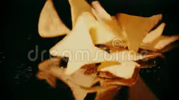 玉米片在黑色背景下掉落并破碎慢镜头视频的预览图