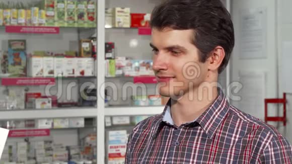 快乐的帅哥微笑着拿着购物袋在药房视频的预览图