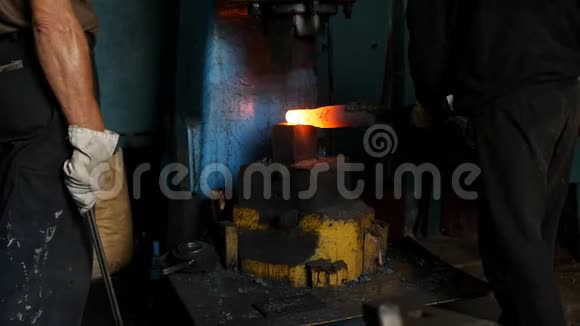 铁匠铺里的铁匠用凿子锤秤慢动作锻造一块金属热片视频的预览图