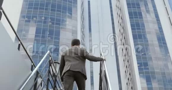 一个年轻英俊的商人爬楼梯到商务中心视频的预览图