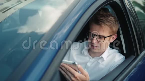 年轻的出租车司机在出租车上开车在笔记本电脑上找路点餐自雇视频的预览图